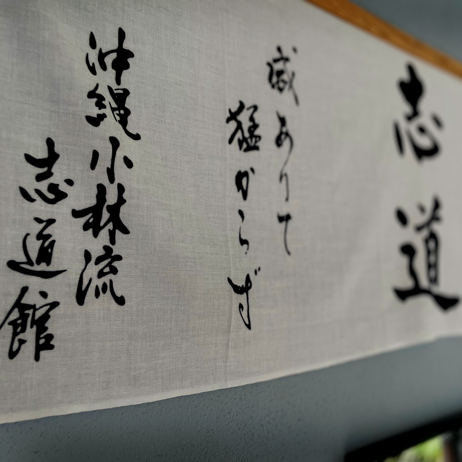 Kalligrafie auf Leinen an der Wand des Dōjō, in schwarzer Tusche geschrieben