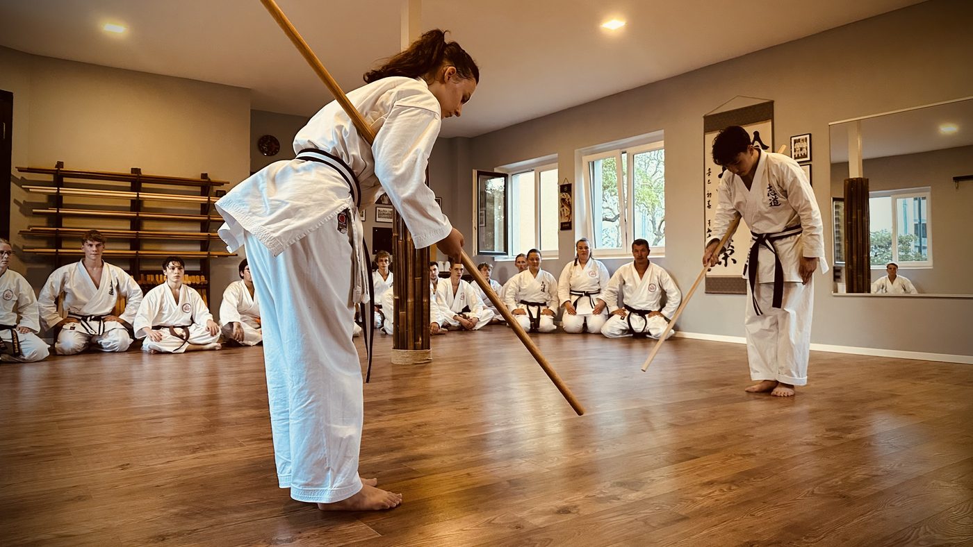 Jugendliche beim Bō-Kobudō im Shirasagi Shima Dōjō, die Gruppe sitzt im Seiza und sieht zu